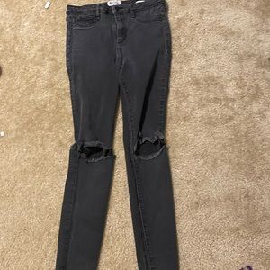 Black jeans, with holes in the knee